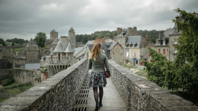 Jeune femme marchant sur les remparts du château de Fougères