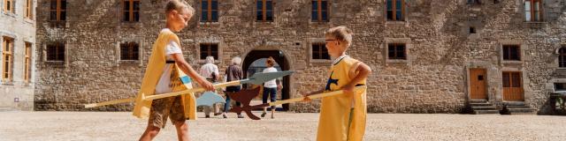 Enfants jouant devant le château du Rocher Portail à Maen Roch