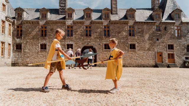 Enfants jouant devant le château du Rocher Portail à Maen Roch