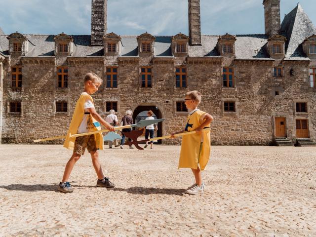 Enfants jouant devant le château du Rocher Portail à Maen Roch