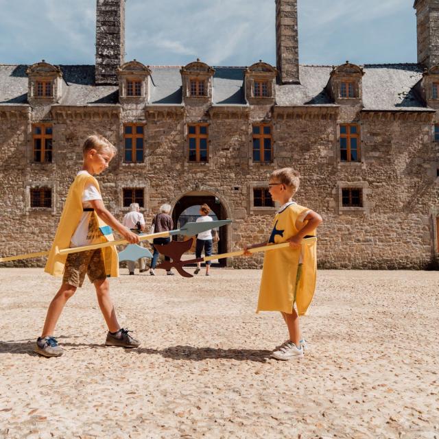 Enfants jouant devant le château du Rocher Portail à Maen Roch