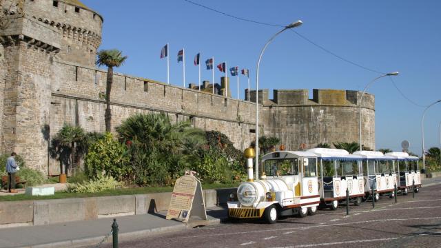 Le Petit train touristique au pied des remparts de Saint-Malo