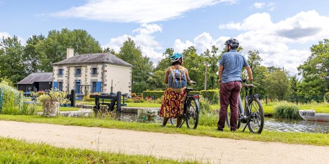 A vélo devant une maison éclusière du canal d'Ille-et-Rance