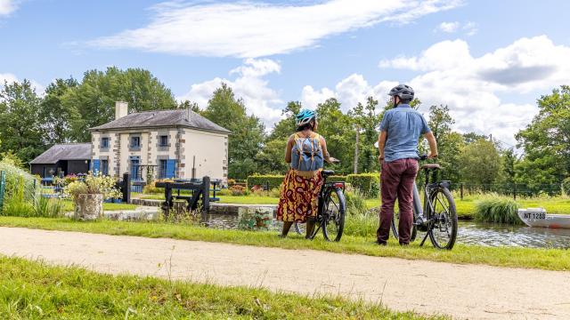 A vélo devant une maison éclusière du canal d'Ille-et-Rance