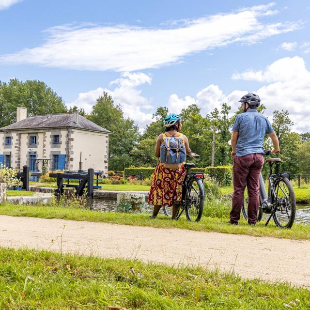 A vélo devant une maison éclusière du canal d'Ille-et-Rance