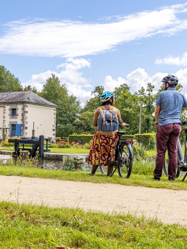 A vélo devant une maison éclusière du canal d'Ille-et-Rance